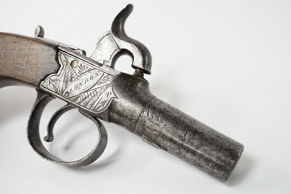 A boxlock percussion pocket pistol, Birmingham proved, frame engraved with flag trophies and signed Cook, London within ovals, sliding top thumb safety, partly chequered walnut grip with vacant silver escutcheon. Conditi